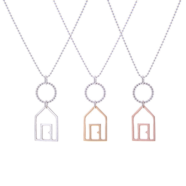 Silver, Yellow and rose gold beach hut pendants on silver chain white background by Kate Wimbush Jewellery