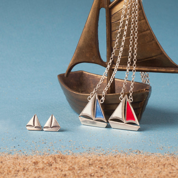 Silver sailing boat studs and pendants with blue and red resin sails by Kate Wimbush Jewellery