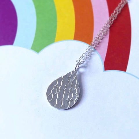 Silver Hand stamped raindrop pendant on rainbow background by Kate Wimbush Jewellery
